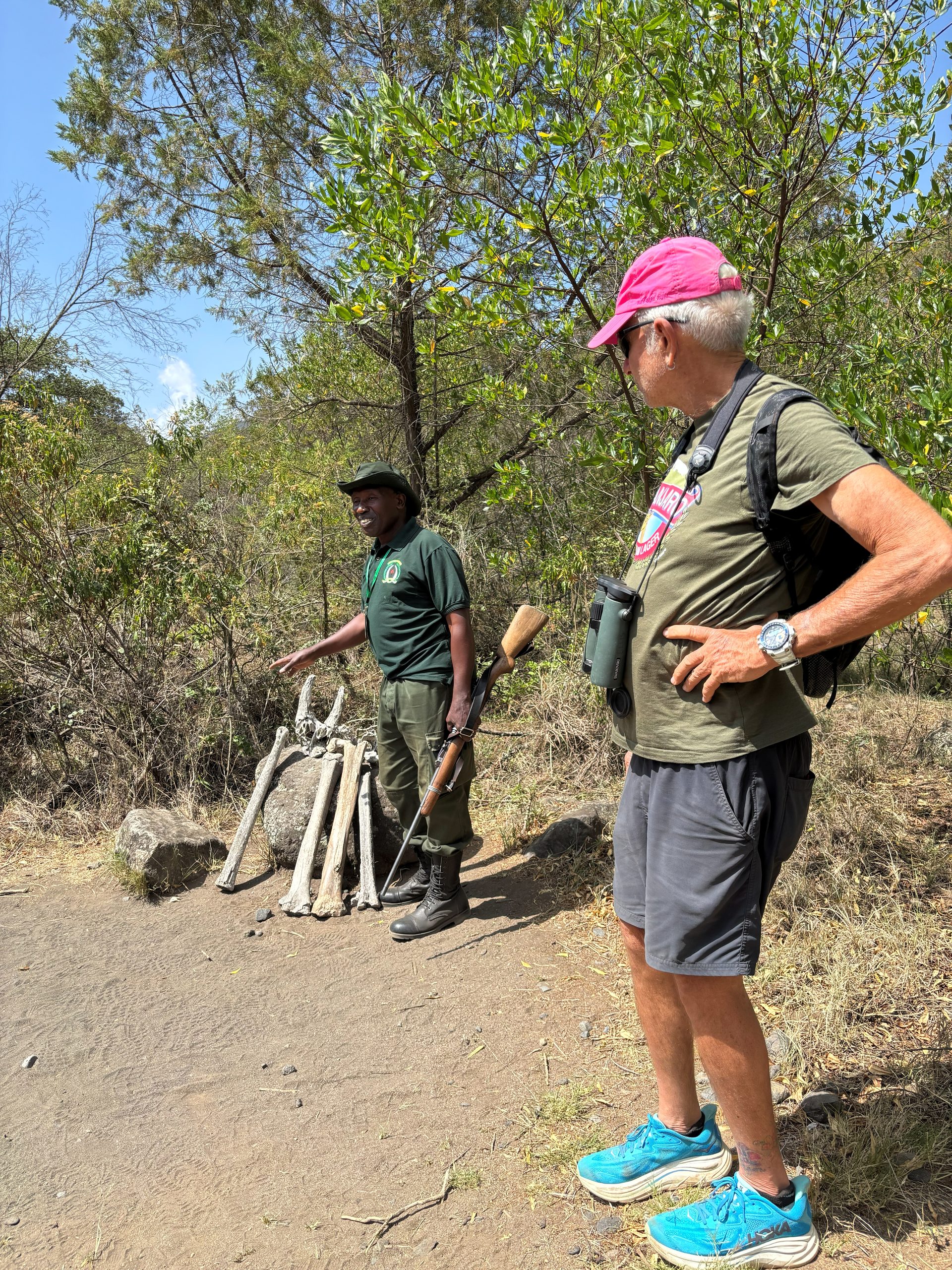 Armed park ranger and group member on walking safari trail